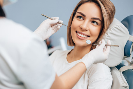 Patient smiling at the dental chair on her first visit of North Hills Implant & Oral Surgery