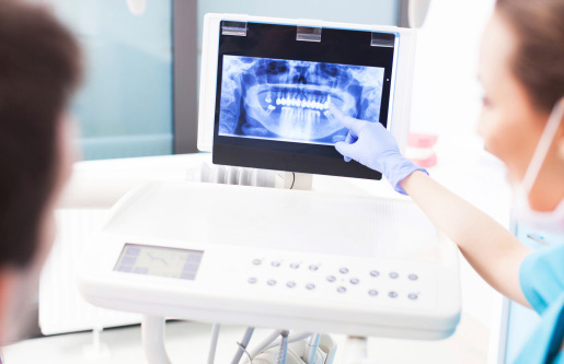Dentist explaining digital x-ray picture to patient at North Hills Implant & Oral Surgery in Raleigh, NC 27609-6518