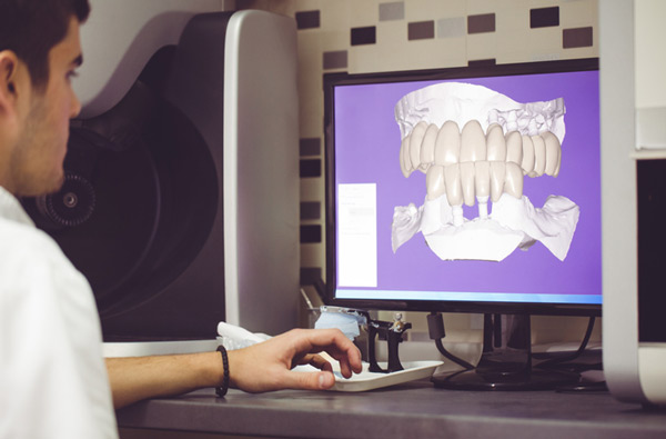 Man sitting at desk looking at a digital dental impression at North Hills Implant & Oral Surgery in Raleigh, NC
